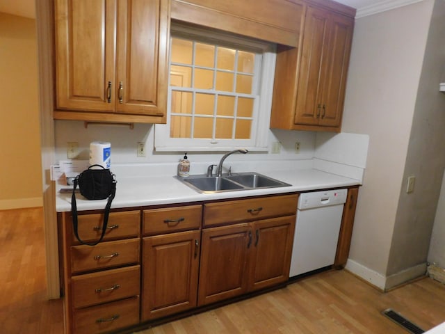 kitchen with sink, crown molding, light hardwood / wood-style flooring, and dishwasher