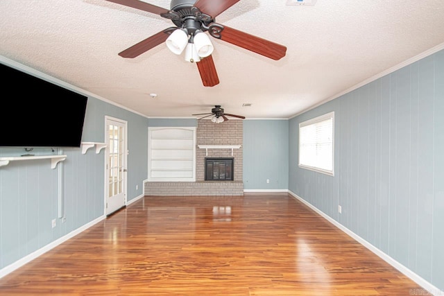 unfurnished living room featuring a brick fireplace, a textured ceiling, ceiling fan, and hardwood / wood-style floors