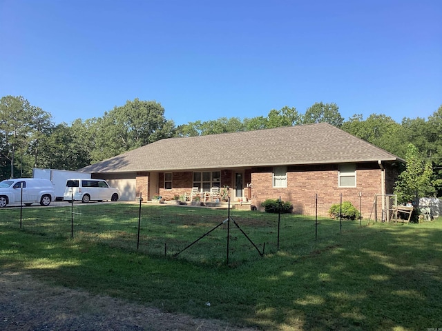 ranch-style house featuring covered porch and a front lawn