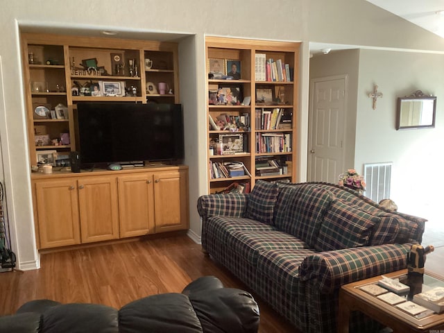 living room featuring hardwood / wood-style flooring and vaulted ceiling