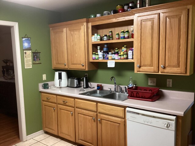 kitchen featuring sink, white dishwasher, and light tile patterned floors