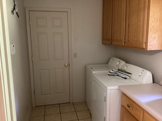 washroom featuring cabinets, washer and dryer, and light tile patterned floors