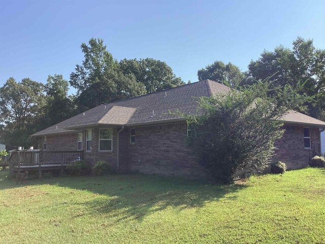 view of side of home with a yard and a wooden deck