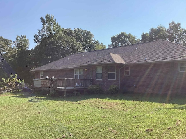 back of property featuring a yard and a wooden deck