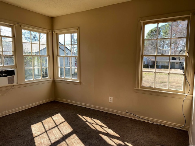 unfurnished room featuring dark colored carpet and a textured ceiling