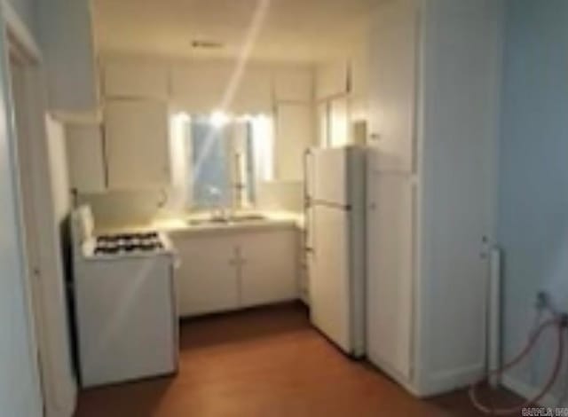 kitchen featuring range, white cabinets, and white refrigerator