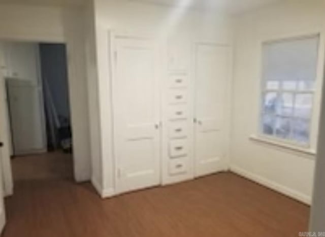 1107 Reynolds St, Clarksville, AR 72830 - unfurnished bedroom with baseboards, a closet, and wood finished floors