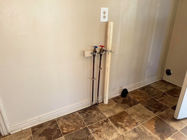 laundry area with dark tile patterned flooring