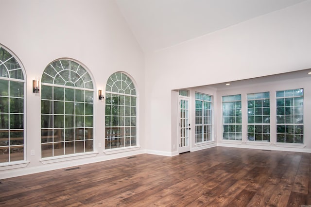 unfurnished living room featuring hardwood / wood-style flooring and high vaulted ceiling