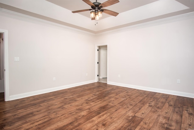 spare room featuring wood-type flooring, ceiling fan, and a raised ceiling