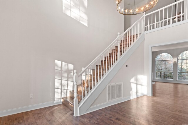 unfurnished room with crown molding, a chandelier, and hardwood / wood-style flooring