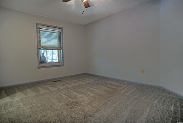 carpeted spare room with a textured ceiling and ceiling fan