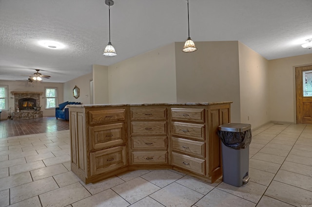 kitchen with a textured ceiling, a fireplace, and light tile patterned floors