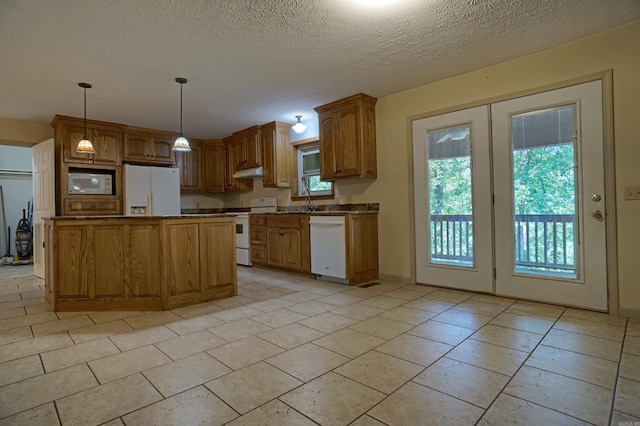 kitchen with a center island, pendant lighting, white appliances, and light tile patterned floors