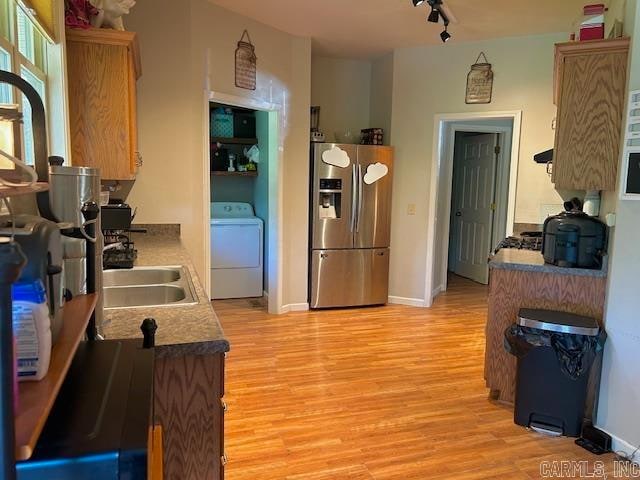 kitchen with washer / dryer, rail lighting, light hardwood / wood-style floors, and stainless steel fridge with ice dispenser