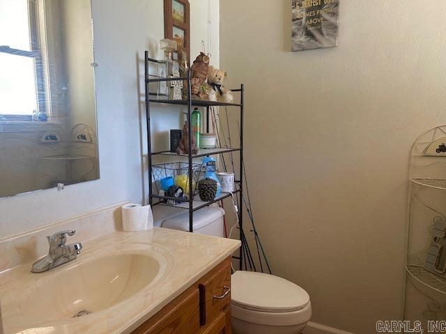 1334 Sutterfield Rd, Fox, AR 72051 - bathroom with toilet, vanity, and baseboards