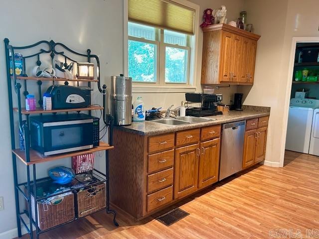 kitchen with dishwasher, light hardwood / wood-style floors, washer and dryer, and sink