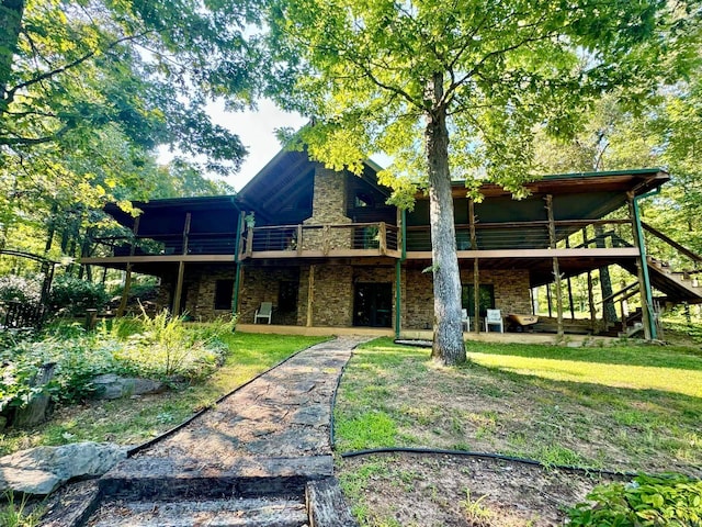 rear view of house with a wooden deck and a lawn