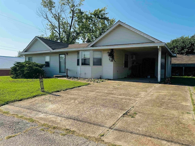 ranch-style house featuring a carport and a front lawn