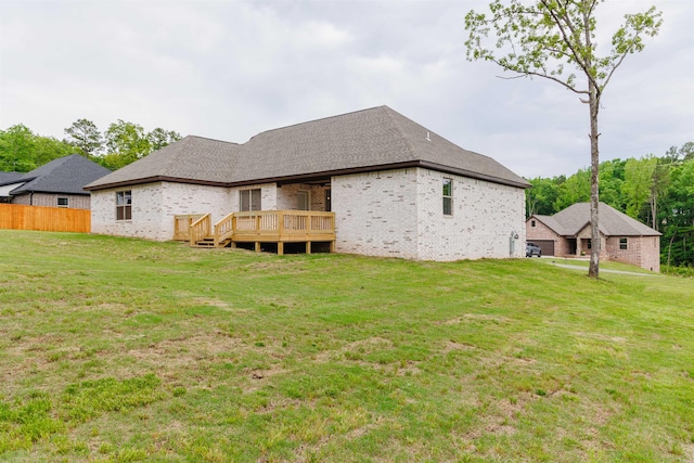 rear view of property with a yard and a deck