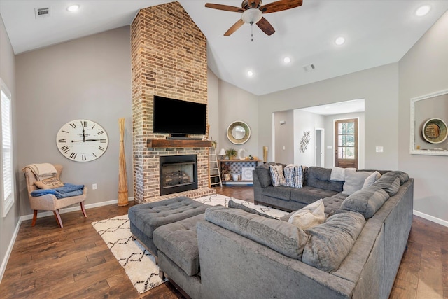 living room with ceiling fan, a fireplace, dark hardwood / wood-style floors, and high vaulted ceiling