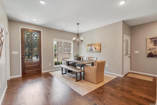 dining area featuring a notable chandelier and dark hardwood / wood-style floors