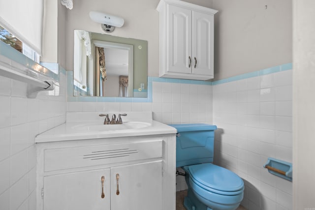 bathroom featuring vanity, toilet, and tile walls