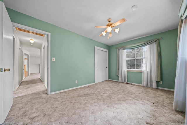 unfurnished bedroom featuring light colored carpet, ceiling fan, and a closet