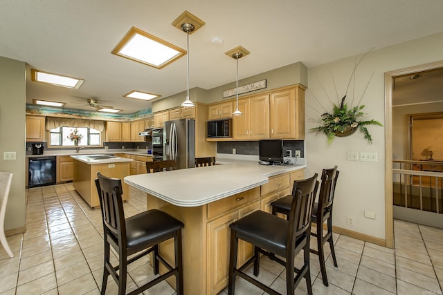 kitchen featuring pendant lighting, a kitchen bar, kitchen peninsula, and black appliances