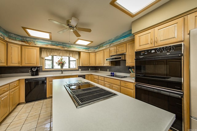 kitchen featuring light tile patterned floors, black appliances, sink, and ceiling fan