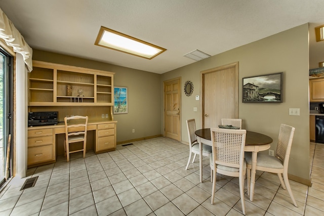 dining area featuring built in desk and light tile patterned floors