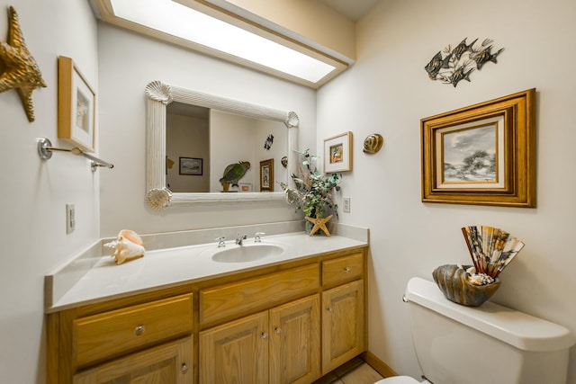 bathroom with vanity, a skylight, and toilet