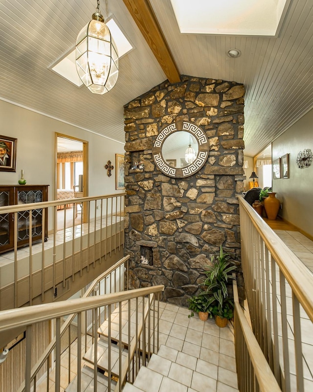 hall featuring light tile patterned floors, a notable chandelier, and vaulted ceiling with skylight