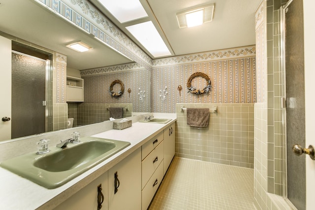 bathroom featuring vanity, tile patterned flooring, a shower with shower door, and toilet