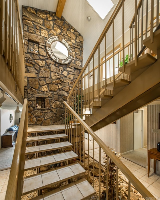 stairway featuring beam ceiling, tile patterned floors, and high vaulted ceiling