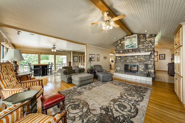 living room with ceiling fan, a fireplace, light hardwood / wood-style flooring, and vaulted ceiling with beams