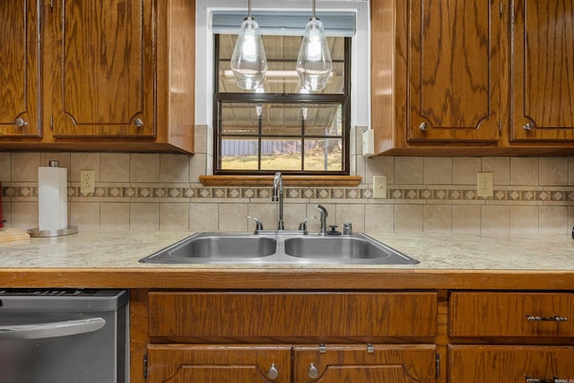 kitchen with dishwasher, tasteful backsplash, sink, and pendant lighting