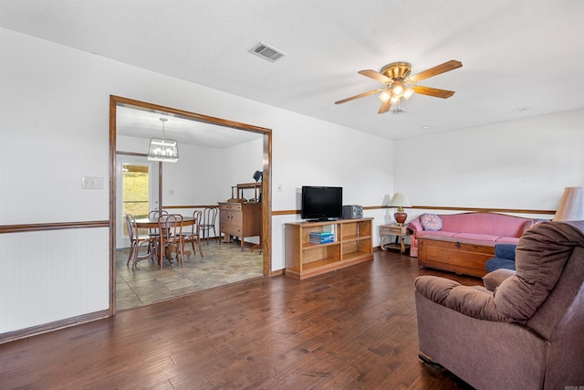 living room featuring ceiling fan with notable chandelier and hardwood / wood-style floors