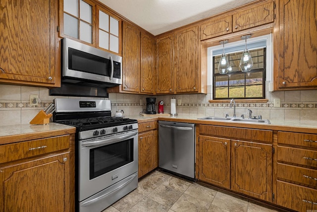 kitchen featuring decorative backsplash, appliances with stainless steel finishes, tile counters, and light tile patterned floors