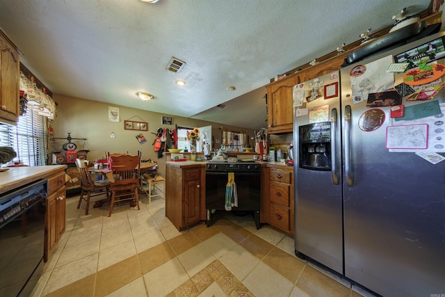 kitchen featuring light tile patterned floors, light countertops, brown cabinetry, a peninsula, and black appliances