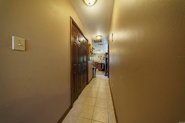 hall with baseboards and light tile patterned floors