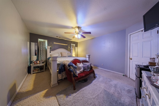 carpeted bedroom featuring ceiling fan, baseboards, and a textured ceiling