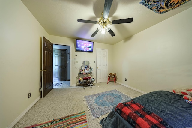 bedroom featuring light colored carpet, ceiling fan, and baseboards