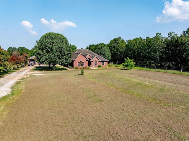 view of front of home featuring driveway, a front lawn, and fence