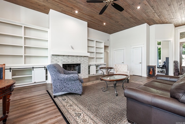 living room with a fireplace, ceiling fan, dark hardwood / wood-style floors, and wood ceiling