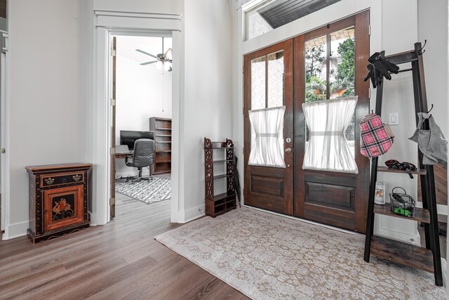 foyer featuring french doors, ceiling fan, and light wood-type flooring