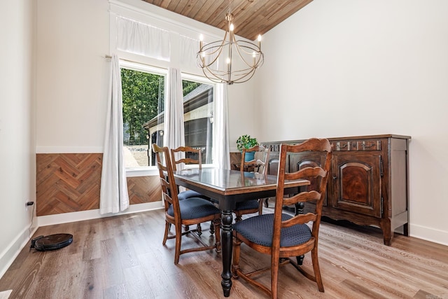 dining space with light hardwood / wood-style floors, a notable chandelier, wooden ceiling, and vaulted ceiling