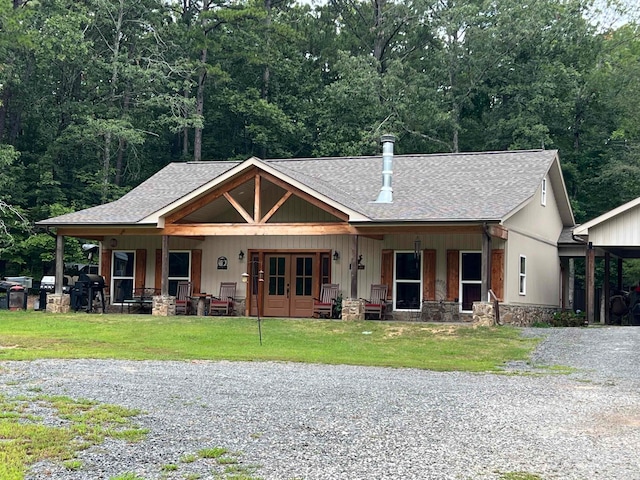 craftsman inspired home with a front lawn, a carport, and covered porch