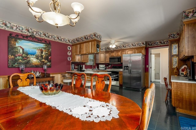 tiled dining room featuring ceiling fan with notable chandelier