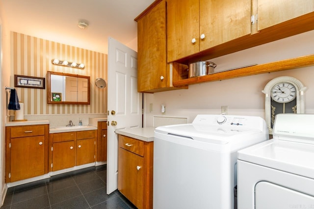 washroom featuring sink, cabinets, dark tile patterned floors, and washer and dryer